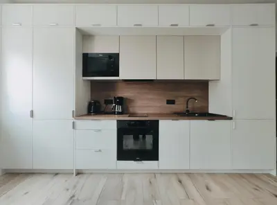 a white kitchen with white cabinets and a sink at Spasowskiego 2 by Homeprime in Kraków