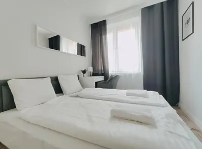 a white bedroom with two beds and a window at Spasowskiego 2 by Homeprime in Kraków