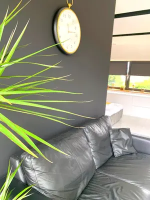 a wooden table with a vase with flowers on it at Apartament 106 in Andrychów