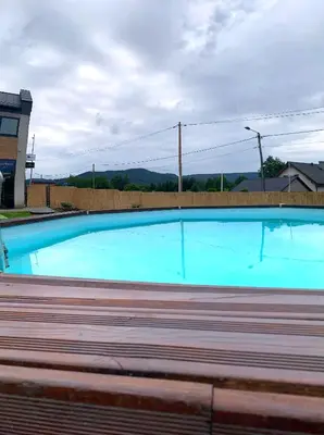 a backyard with a swimming pool and a playground at Apartament 106 in Andrychów