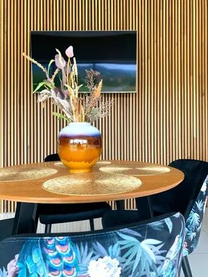 a hot tub sitting on a wooden deck with a bench and aitating at Apartament 106 in Andrychów