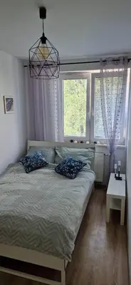 a bedroom with a bed and two windows at Cosy Apartment w pobliżu Tauron Arena in Kraków