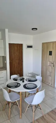 a kitchen with a white table and white chairs at Cosy Apartment w pobliżu Tauron Arena in Kraków