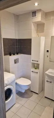 a bathroom with a toilet and a washing machine at Cosy Apartment w pobliżu Tauron Arena in Kraków
