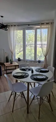 a dining room with a white table and chairs at Cosy Apartment w pobliżu Tauron Arena in Kraków