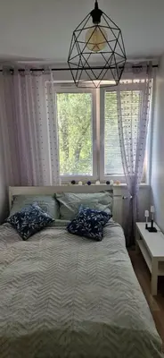 a bedroom with a large bed with two pillows on it at Cosy Apartment w pobliżu Tauron Arena in Kraków
