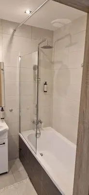 a bathroom with a shower and a bath tub at Cosy Apartment w pobliżu Tauron Arena in Kraków