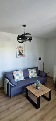 a living room with a blue couch and a table at Cosy Apartment w pobliżu Tauron Arena in Kraków