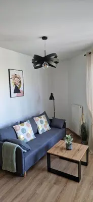 a living room with a blue couch and a table at Cosy Apartment w pobliżu Tauron Arena in Kraków