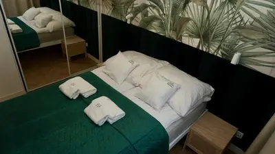 a bedroom with a bed with towels on it at Castle Apartments - Queen in Oświęcim