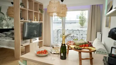 a table with a bowl of fruit and a bottle of wine at Castle Apartments - Queen in Oświęcim