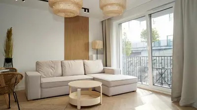 a living room with a white couch and a table at Castle Apartments - King in Oświęcim
