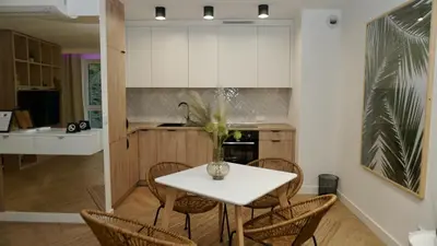 a kitchen with a white table and chairs at Castle Apartments - King in Oświęcim