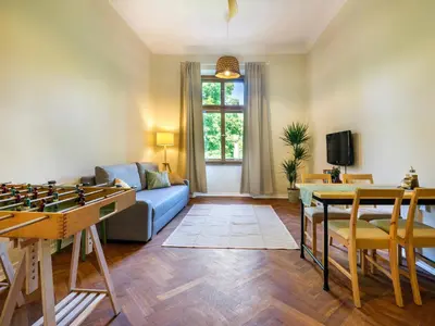 a living room with a blue couch and a table at Bed & Beige Apartment / Kochanowskiego St in Kraków