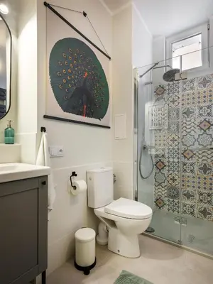a bathroom with a toilet and a glass shower at Bed & Beige Apartment / Kochanowskiego St in Kraków