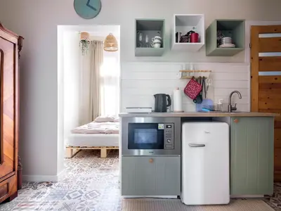a kitchen with a counter with a microwave and a refrigerator at Bed & Beige Apartment / Kochanowskiego St in Kraków