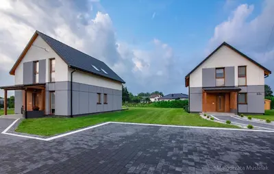 a large white house with a parking lot at Apartamenty u Edzi in Zator