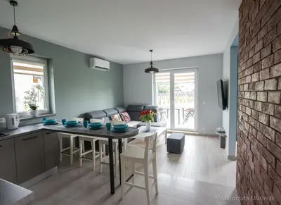 a kitchen and living room with a table and chairs at Apartamenty u Edzi in Zator