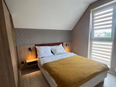 a bedroom with a large bed with a large window at Apartamenty u Edzi in Zator