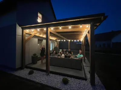a group of people sitting on a patio at night at Apartamenty u Edzi in Zator
