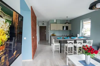 a kitchen and living room with a table and chairs at Apartamenty u Edzi in Zator