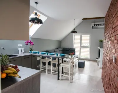 a kitchen and living room with a table and chairs at Apartamenty u Edzi in Zator