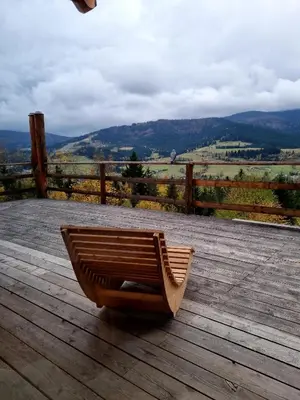 a wooden chair sitting on a wooden deck at Domek w drapie in Lubomierz