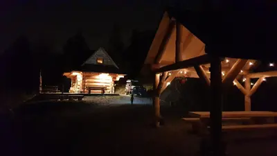 a log cabin at night with lights on it at Domek w drapie in Lubomierz