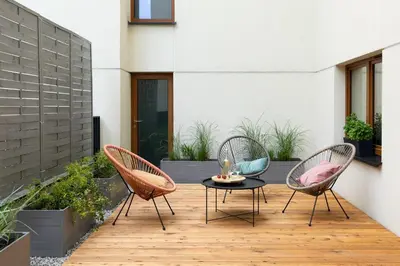 a patio with two chairs and a table on a deck at No 7 Terrace in Kraków