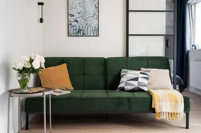 a green couch in a living room with a table at No 7 Terrace in Kraków