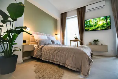 a bedroom with a large bed and a potted plant at Zator Apartament MINT wanna spa in Zator