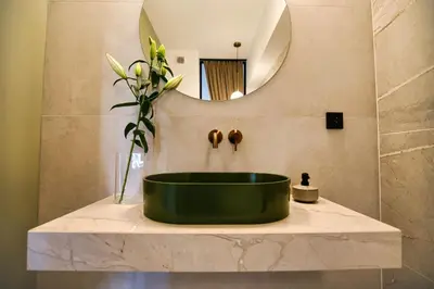 a bathroom with a green tub on a marble counter with a mirror at Zator Apartament MINT wanna spa in Zator