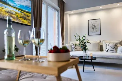 a living room with a couch and a table with wine glasses at Zator Apartament MINT wanna spa in Zator