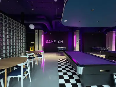 a room with three pool tables on a checkered floor at Chillout Dorm Cracow by BookingHost in Kraków