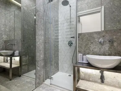 a bathroom with a glass shower and a sink at Tyzenhauz Grand Apartaments in Kraków