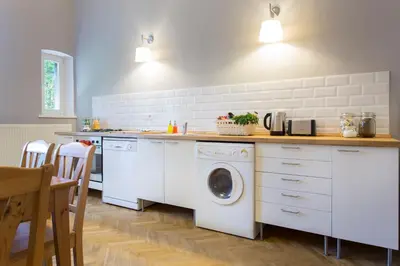 a kitchen with a washer and dryer on a counter at Tyzenhauz Grand Apartaments in Kraków