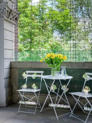 a table and chairs with a vase of yellow flowers at Tyzenhauz Grand Apartaments in Kraków