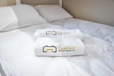 two towels sitting on top of a white bed at Comfort Apartments Oświęcim in Oświęcim