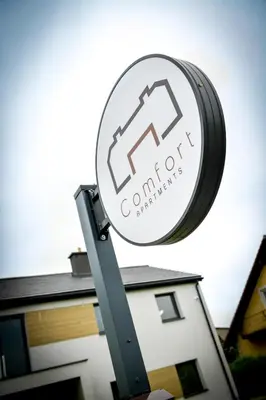 a sign for a construction company in front of a house at Comfort Apartments Oświęcim in Oświęcim