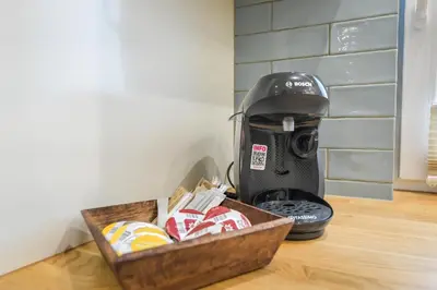 a coffee maker sitting next to a box of cookies at Comfort Apartments Oświęcim in Oświęcim