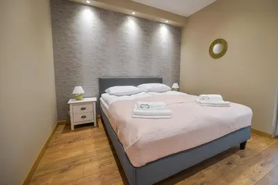 a bedroom with a bed with two towels on it at Comfort Apartments Oświęcim in Oświęcim