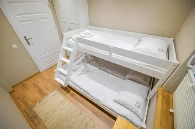 a white bunk bed in a small room at Comfort Apartments Oświęcim in Oświęcim
