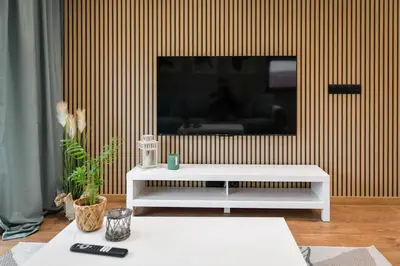 a living room with a tv on a wall at Comfort Apartments Oświęcim in Oświęcim