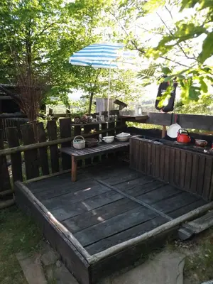 a wooden deck with a table and an umbrella at Małopolskie Swojskie in Olszyny