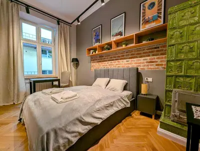 a bedroom with a bed and a brick wall at Bonerowska 5 by Homeprime in Kraków