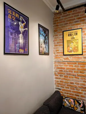 a living room with two posters on a brick wall at Bonerowska 5 by Homeprime in Kraków