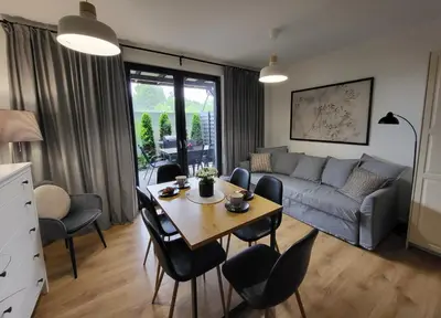 a living room with a table and a couch at Lipowy Zakątek - domki blisko Energylandii i stacji PKP w Zatorze in Zator