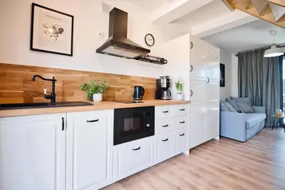 a kitchen with white cabinets and a sink at Lipowy Zakątek - domki blisko Energylandii i stacji PKP w Zatorze in Zator