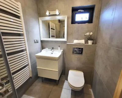 a bathroom with a sink and a toilet and a mirror at Lipowy Zakątek - domki blisko Energylandii i stacji PKP w Zatorze in Zator
