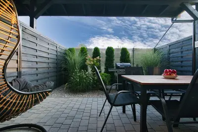 a patio with a table and chairs and a fence at Lipowy Zakątek - domki blisko Energylandii i stacji PKP w Zatorze in Zator